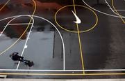 An employee speaks on a mobile phone as he strolls past a Swoosh on a basketball court at the Nike headquarters near Beaverton on March 22, 2018.
