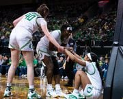 Oregon’s Chance Gray (right) gets helped up by teammates as the Ducks take on the North Dakota State Bison in a first-round WNIT game on Friday, March 17, 2023, at Matthew Knight Arena in Eugene. 
