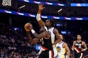 Portland Trail Blazers center Duop Reath (26) shoots against Golden State Warriors forward Kevon Looney, back, during the first half of an NBA basketball game in San Francisco, Wednesday, Dec. 6, 2023. (AP Photo/Jed Jacobsohn) AP