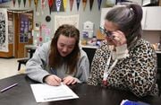 Madras senior Alice Belgarde (left) gets help Tuesday afternoon on a home energy audit assessment project from Samantha Loza, a Madras High college and career coordinator.