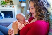 Emily Bendt cradles her 2-week-old infant, Willow, in early October 2023. Bendt, a pediatric nurse, closely followed the approval of the RSV monoclonal antibody nirsevimab but has been unable to find it for her daughter. (AMELIA TEMPLETON/OPB)